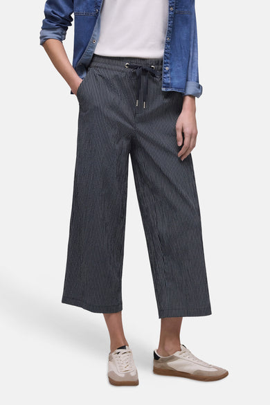 Pantalon bleu marine rayé blanc de STREET ONE, coupe large avec taille élastiquée et cordon de serrage, porté avec une chemise en jean et des baskets claires.