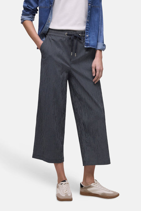 Pantalon bleu marine rayé blanc de STREET ONE, coupe large avec taille élastiquée et cordon de serrage, porté avec une chemise en jean et des baskets claires.