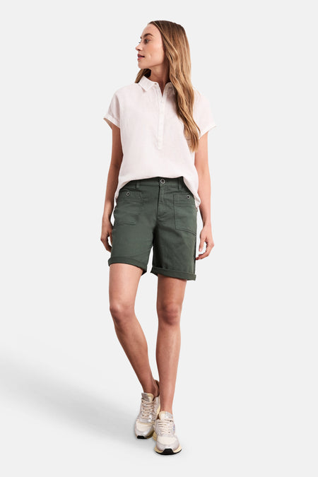 Bermuda kaki de STREET ONE à revers, poches plaquées, porté avec une chemise blanche et des baskets.