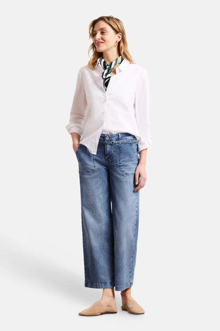 Jean large en denim bleu moyen de STREET ONE à fines rayures verticales, porté avec une chemise blanche et un foulard.