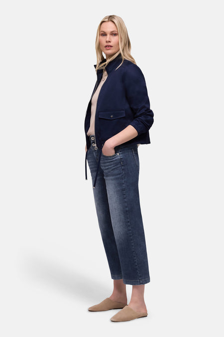 Jean large en denim bleu moyen de Street One, porté avec une veste bleu marine et des mules beiges.
