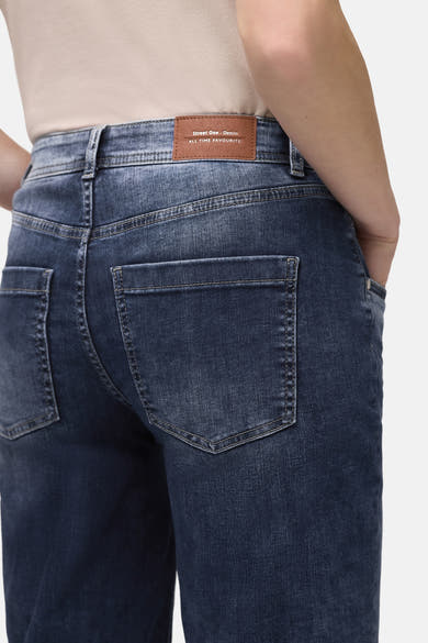 Jean large en denim bleu moyen de Street One, avec des poches arrière carrées et une étiquette marron à la taille.
