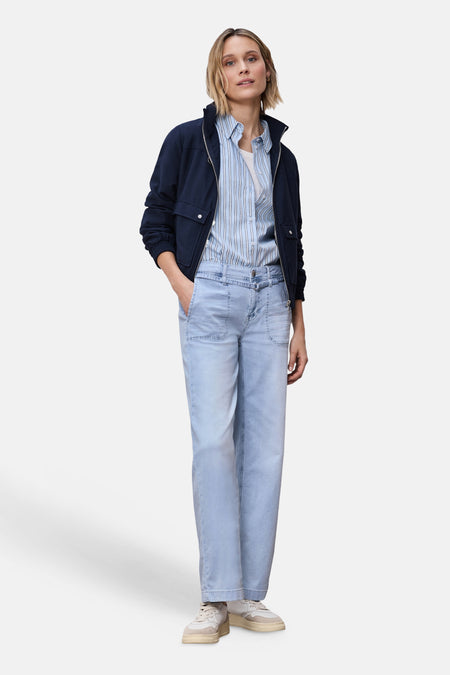 Jean large en denim bleu clair de STREET ONE, porté avec une chemise rayée, un blouson marine et des baskets claires.