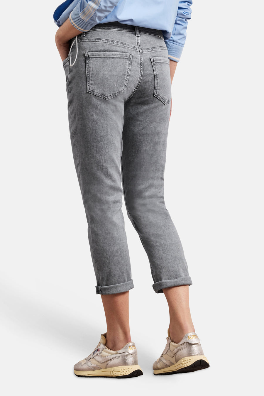 Grijze denim slim fit jeans van STREET ONE, van achteren gezien, opgerold bij de enkels, gedragen met sneakers en een blauw overhemd.
