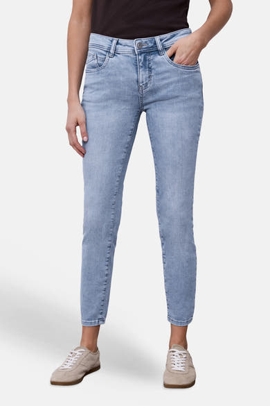 Jean slim en denim bleu clair de Street One, porté avec des baskets en daim beige.