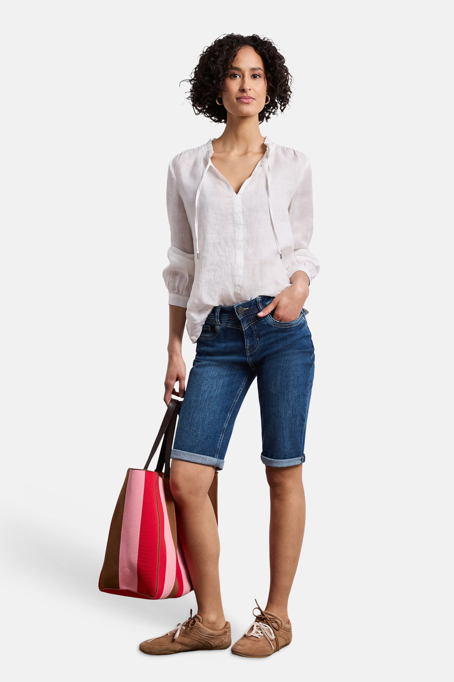 Bermuda en jean bleu moyen de STREET ONE, avec revers, taille boutonnée et coutures apparentes, porté par un mannequin.