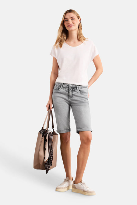 Bermuda en jean gris moyen de STREET ONE, retroussé, avec un t-shirt blanc et un sac cabas beige.