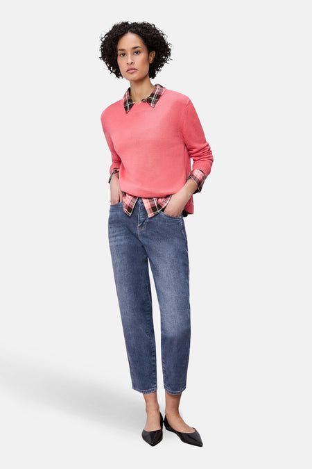 Jean bleu denim mi-long de Street One, porté avec un pull rose et une chemise à carreaux.