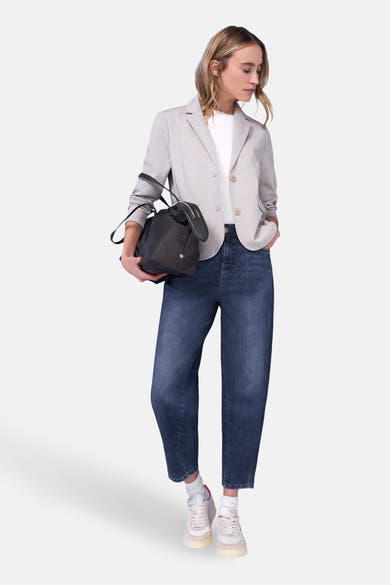 Middelblauwe spijkerbroek van STREET ONE, gedragen met een grijze blazer en witte sneakers.