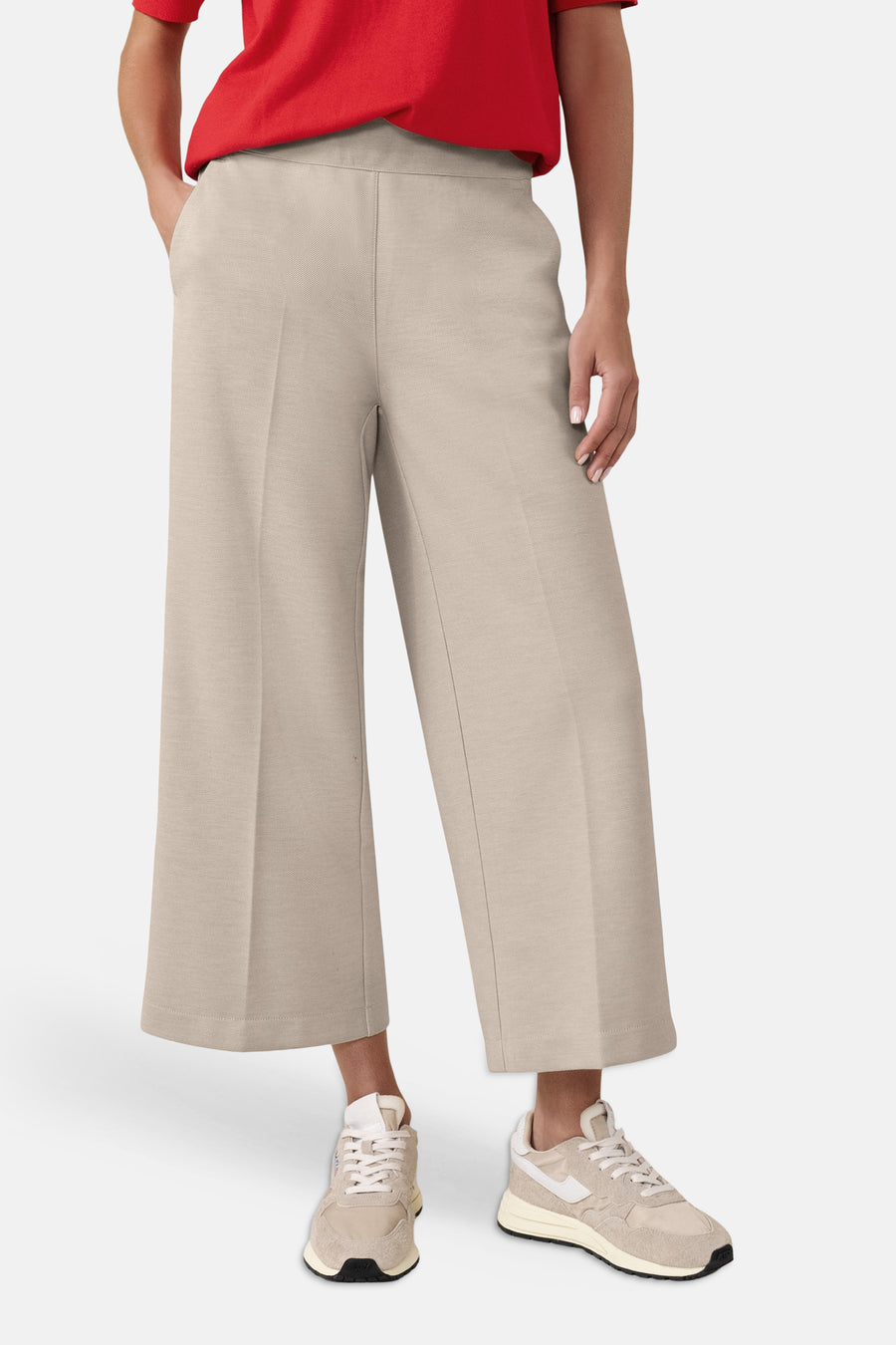 Beige kostuumbroek van Street One, wijd met plooien, gedragen met een rode top en sneakers.