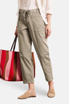 Beige broek van STREET ONE met trekkoord taille en cargozakken, gedragen met wit overhemd, muiltjes en gestreepte tas.