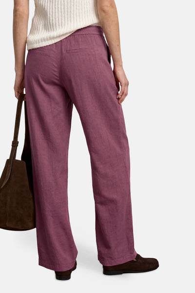 Roze wijde broek van STREET ONE met elastische tailleband, achterkant, gedragen met een bruine tas.