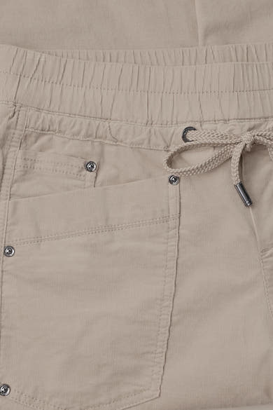 Beige cotton pants with elastic waistband and drawstring, featuring front pockets with silver snap buttons, close-up front view