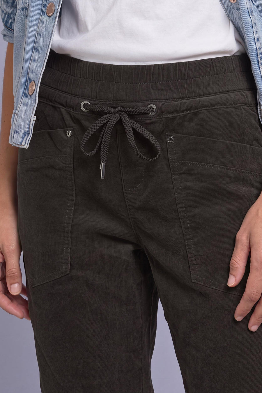 Brown corduroy pants by STREET ONE with elastic waist, drawstring, and front pockets, worn with white top and denim jacket.