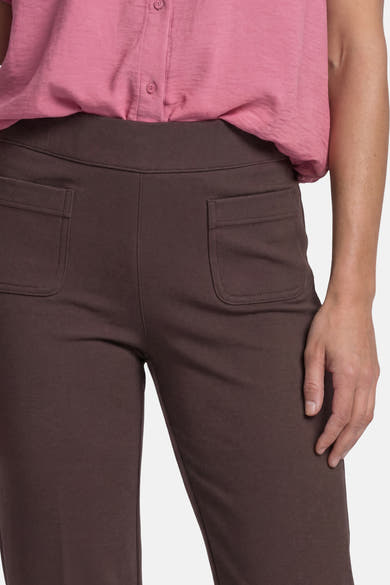 Brown tailored trousers with elastic waistband and back pockets by STREET ONE, shown on model in side view with pink top.