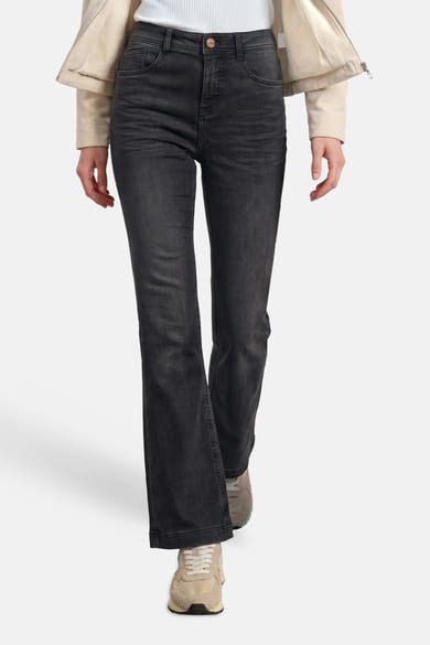 Black bootcut denim jeans by STREET ONE, featuring a faded wash, classic five-pocket design, and straight-leg flare, shown on model with cream jacket and sneakers.