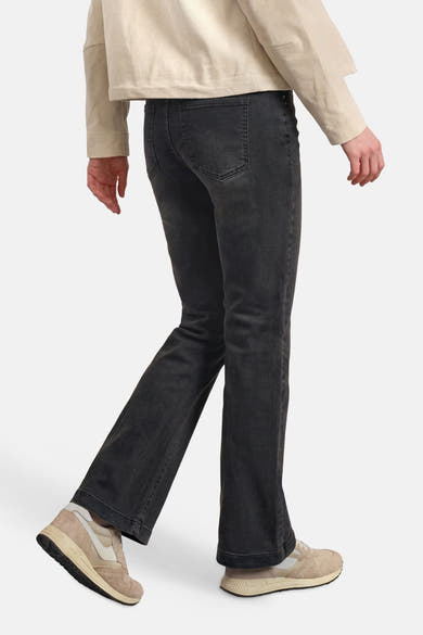 Black bootcut denim jeans by STREET ONE, side view showing flared legs and back pockets, worn with beige top and sneakers