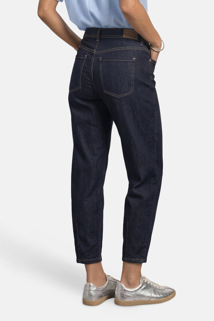 Dark blue denim jeans by STREET ONE, back view with slim tapered fit, visible stitching, and silver sneakers.