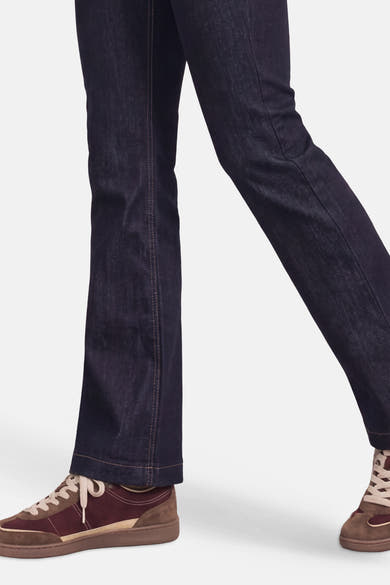 Détail d’un jean bootcut en denim bleu foncé STREET ONE porté avec des baskets