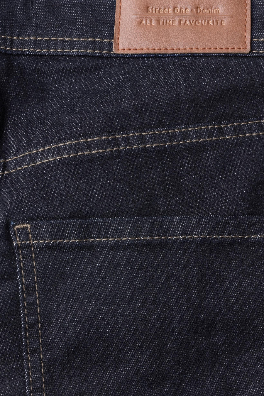 Gros plan sur un jean bootcut en denim bleu foncé STREET ONE, avec surpiqûres contrastantes et étiquette en cuir.