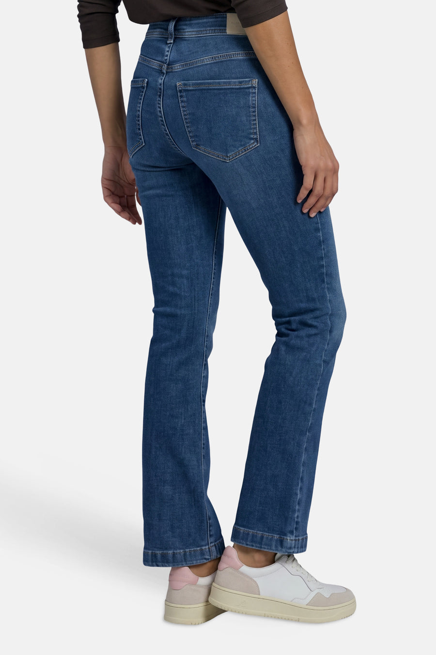 Vue arrière d’un jean bootcut bleu denim STREET ONE porté avec des baskets.