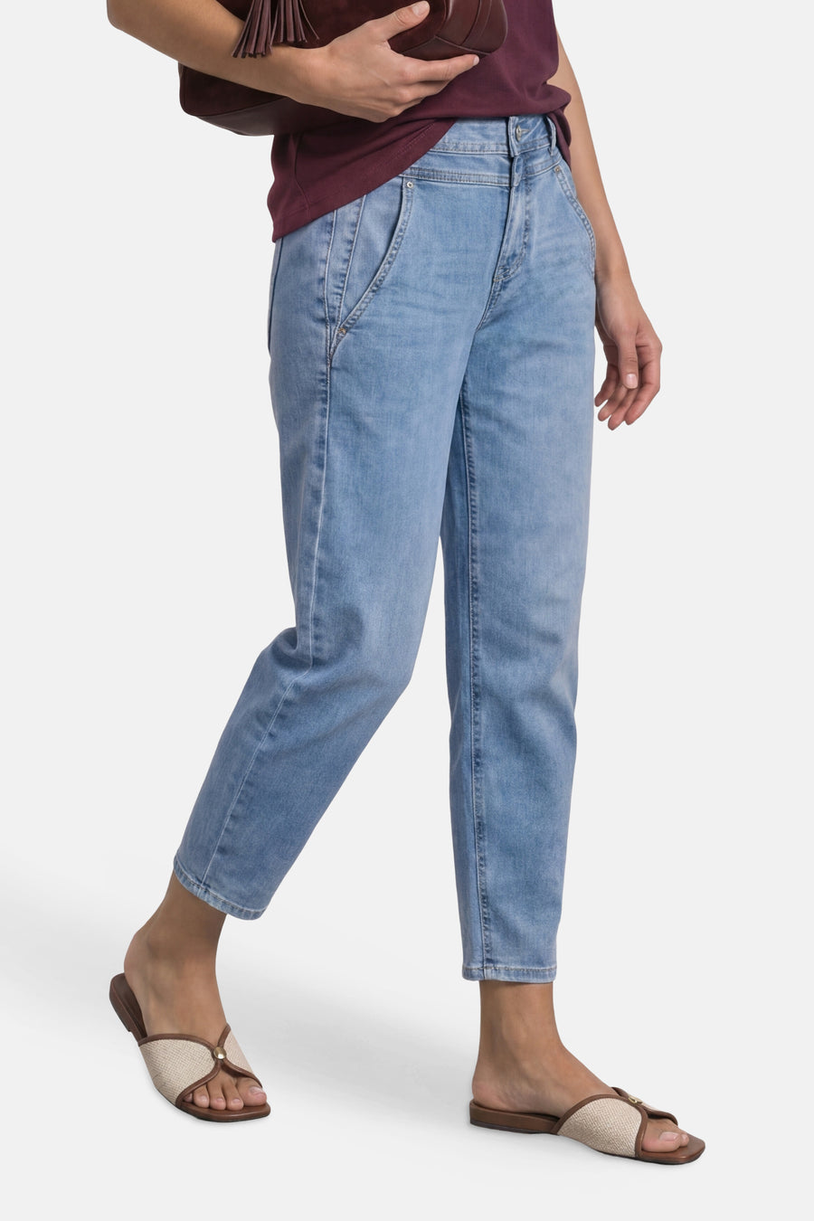 Light blue high-rise cropped denim jeans by STREET ONE, featuring relaxed fit and subtle fading, worn with burgundy top and beige sandals.