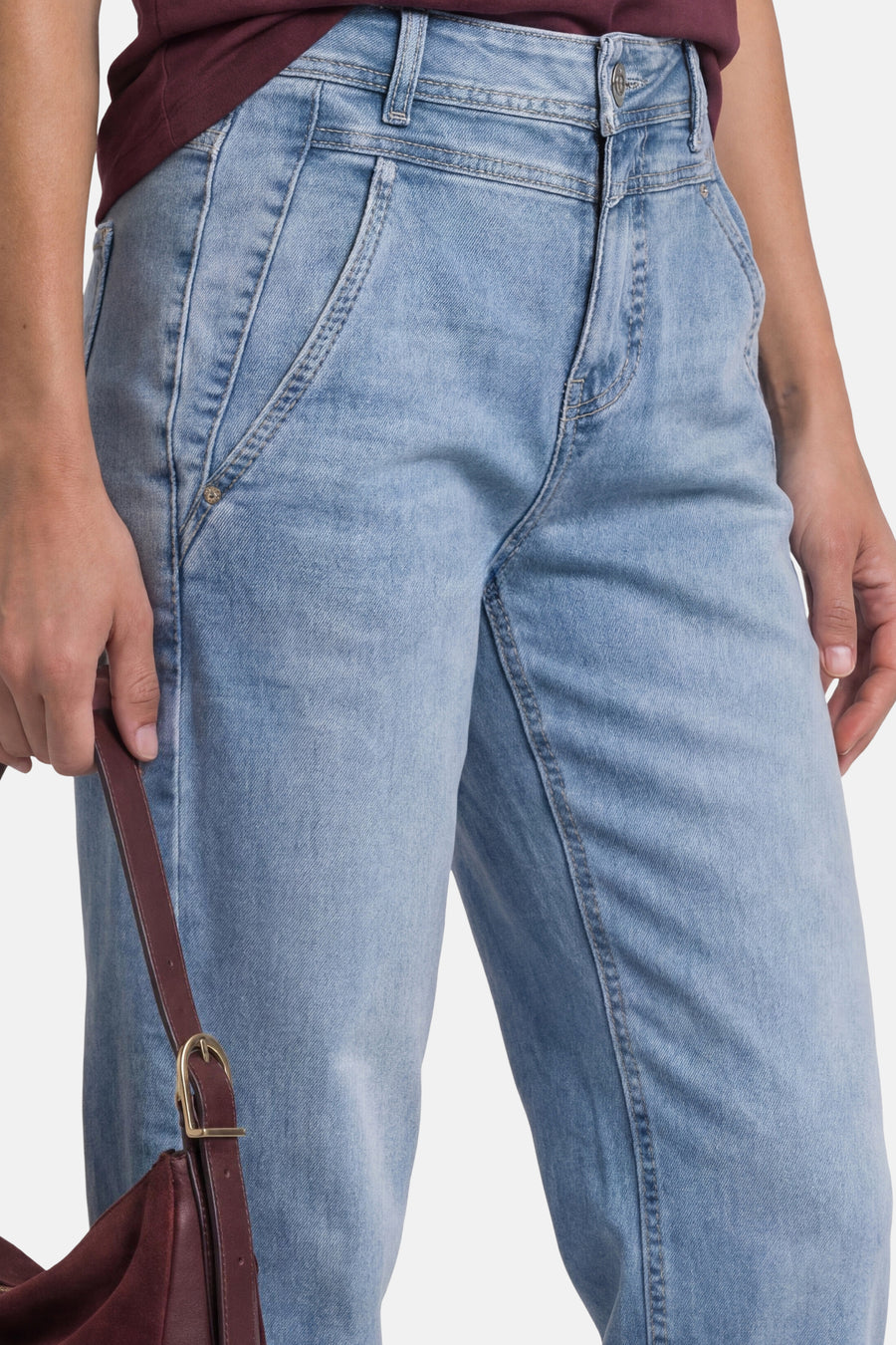 Light blue denim jeans by STREET ONE, featuring a relaxed fit with faded wash and visible stitching, shown from front view on model wearing maroon top.