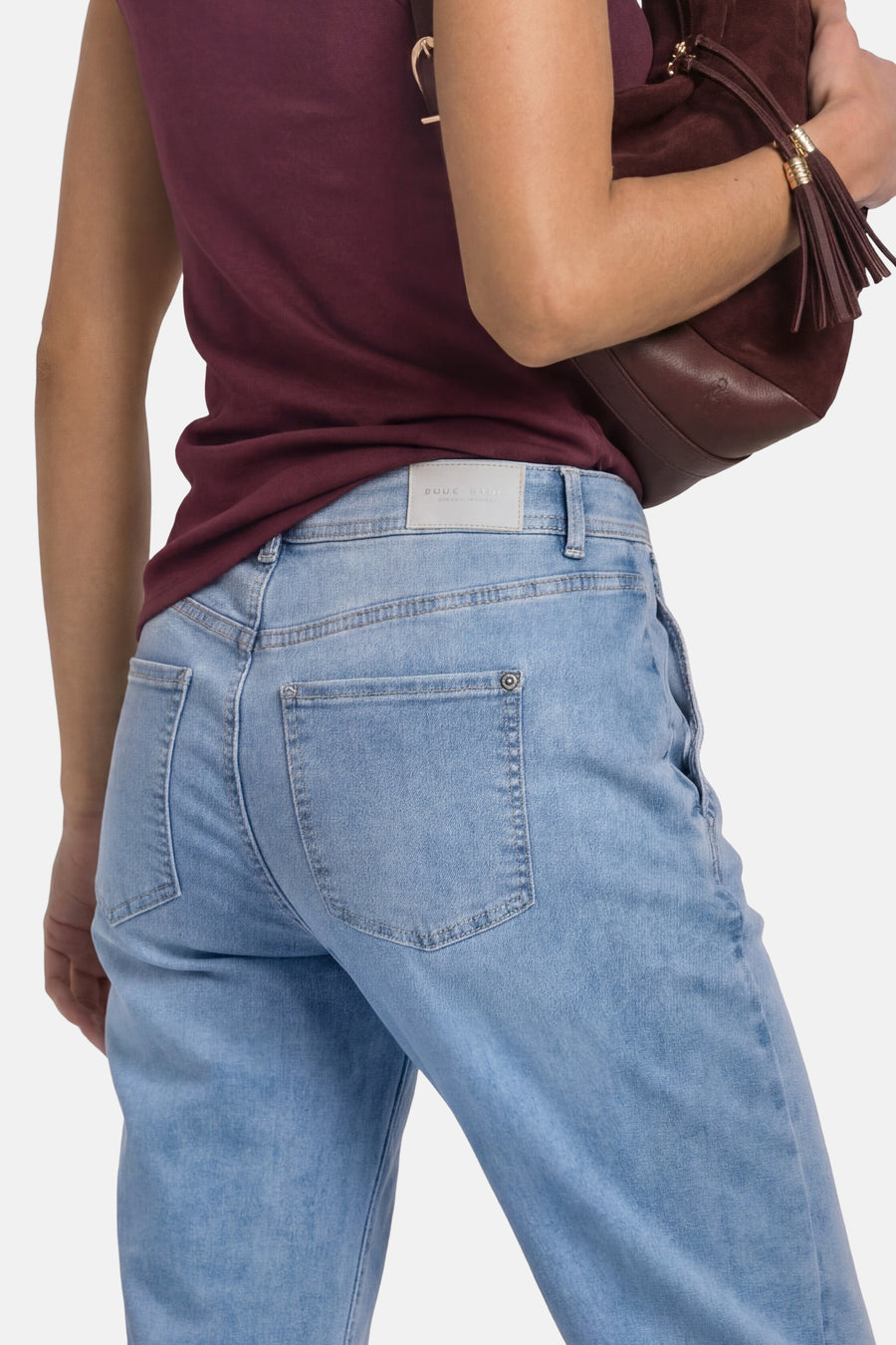 Light blue denim jeans by STREET ONE, back view showing faded wash, classic stitching, and two rear pockets with button accents.
