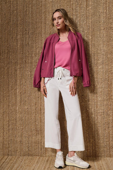 White elastic-waist seasonal pants by STREET ONE, featuring drawstring waist and cuffed hem, worn with pink top and burgundy bomber jacket in lifestyle full-body view.