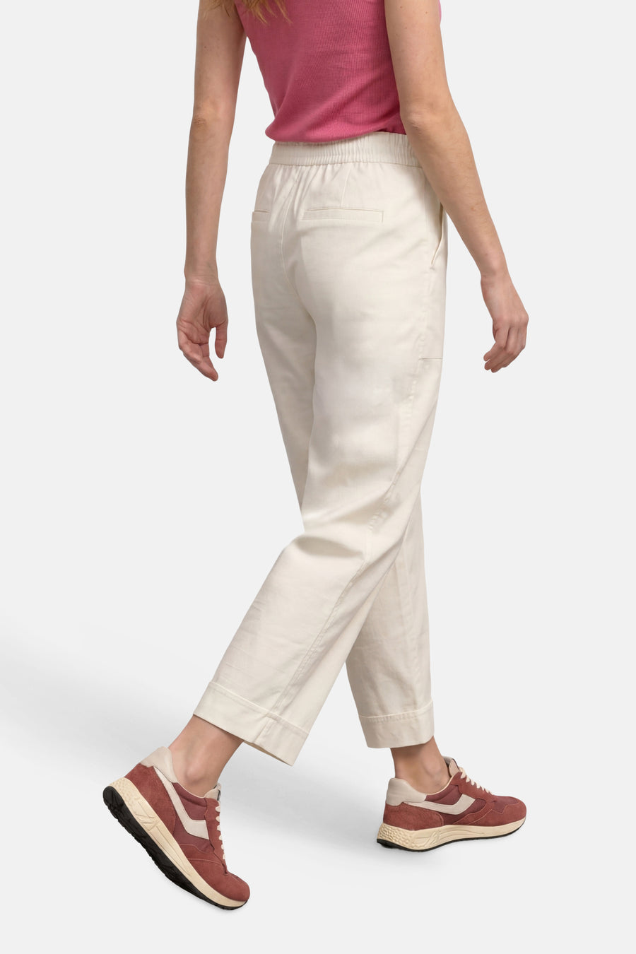 Cream elastic-waist women's seasonal pants by STREET ONE, side view with cuffed hems and back pockets, worn with pink top and brown sneakers