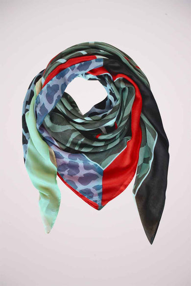 Blue camouflage-patterned square scarf by STREET ONE, featuring bold red and green accents, soft satin texture, styled in a looped knot against white background.