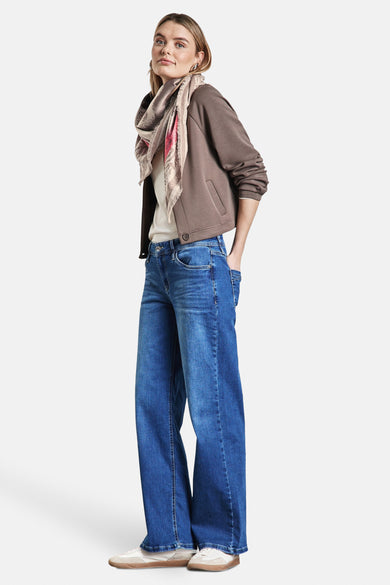 Multikleurige sjaal van Street One met een print, gedragen met een bruin jack en een blauwe jeans.