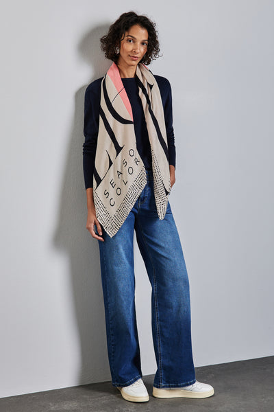 Multikleurige sjaal van Street One, met abstracte print en tekst, gedragen met een marineblauwe trui en een wijde jeans.