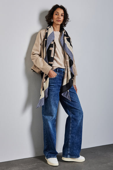 Multicolore sjaal van Street One, met geometrische patronen, gedragen met een beige blouse en een wijde jeans.