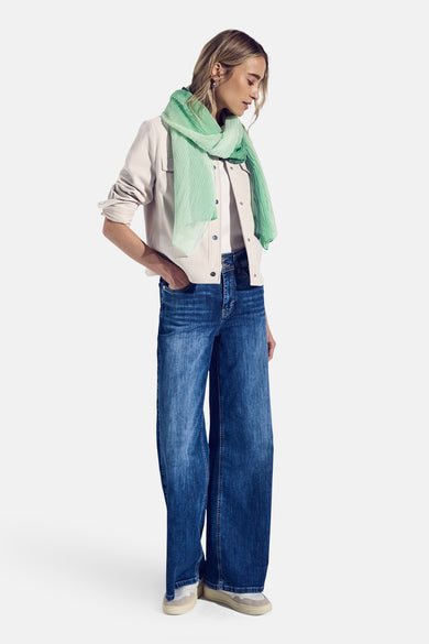 Foulard vert de STREET ONE, plissé, porté avec une veste beige et un jean large bleu.
