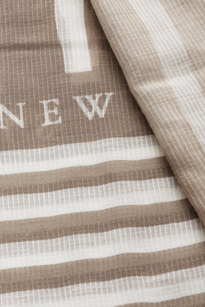 Foulard beige en maille gaufrée par Street One, avec rayures et motif « NEW » blanc.
