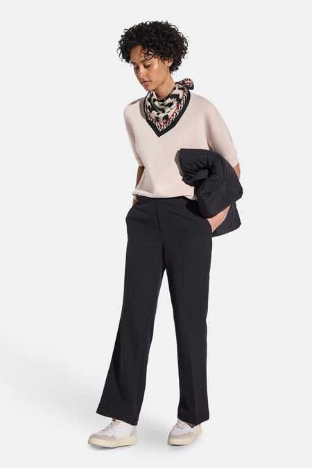 Foulard noir de Street One avec motif imprimé, porté autour du cou avec un haut et un pantalon noirs.

