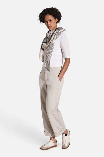 Foulard beige de Street One, à motif, porté avec un t-shirt blanc et un pantalon beige, vue de côté.
