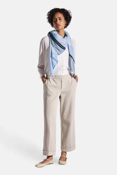 Foulard bleu imprimé de STREET ONE, porté autour du cou avec une chemise blanche et un pantalon beige.
