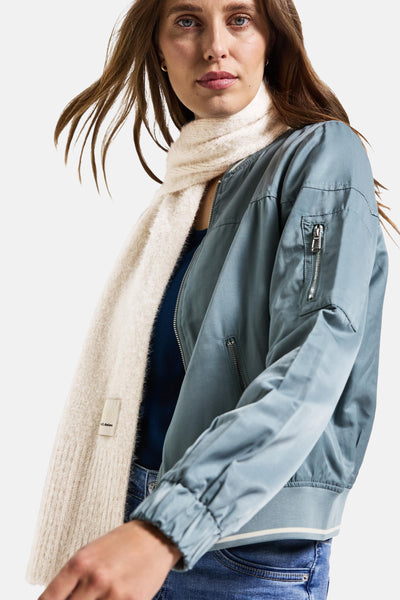 Écharpe écru de Street One, portée avec une veste aviateur bleu clair et un jean.
