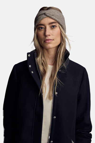 Chapeau brun de STREET ONE, porté avec un bandeau tressé et une veste marine à fermeture éclair.
