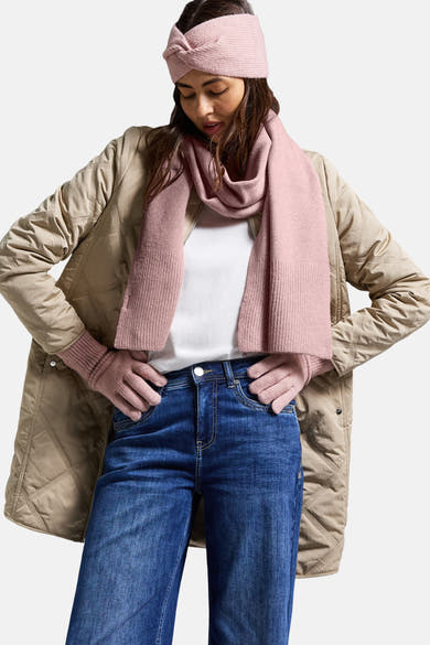 Roze sjaal van STREET ONE, gedragen met bijpassende muts, handschoenen, beige gewatteerd jack en blauwe jeans.