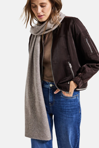 Lichtbruine sjaal van STREET ONE, gedragen om de nek met een bruin jack en een blauwe jeans.