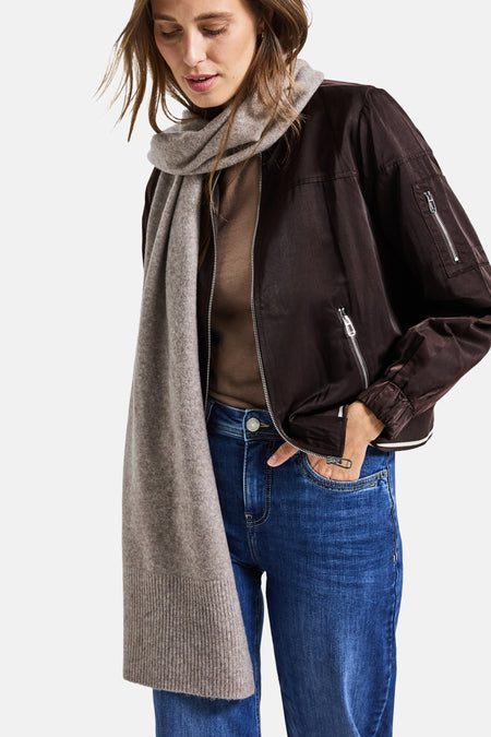 Lichtbruine sjaal van STREET ONE, gedragen om de nek met een bruin jack en een blauwe jeans.
