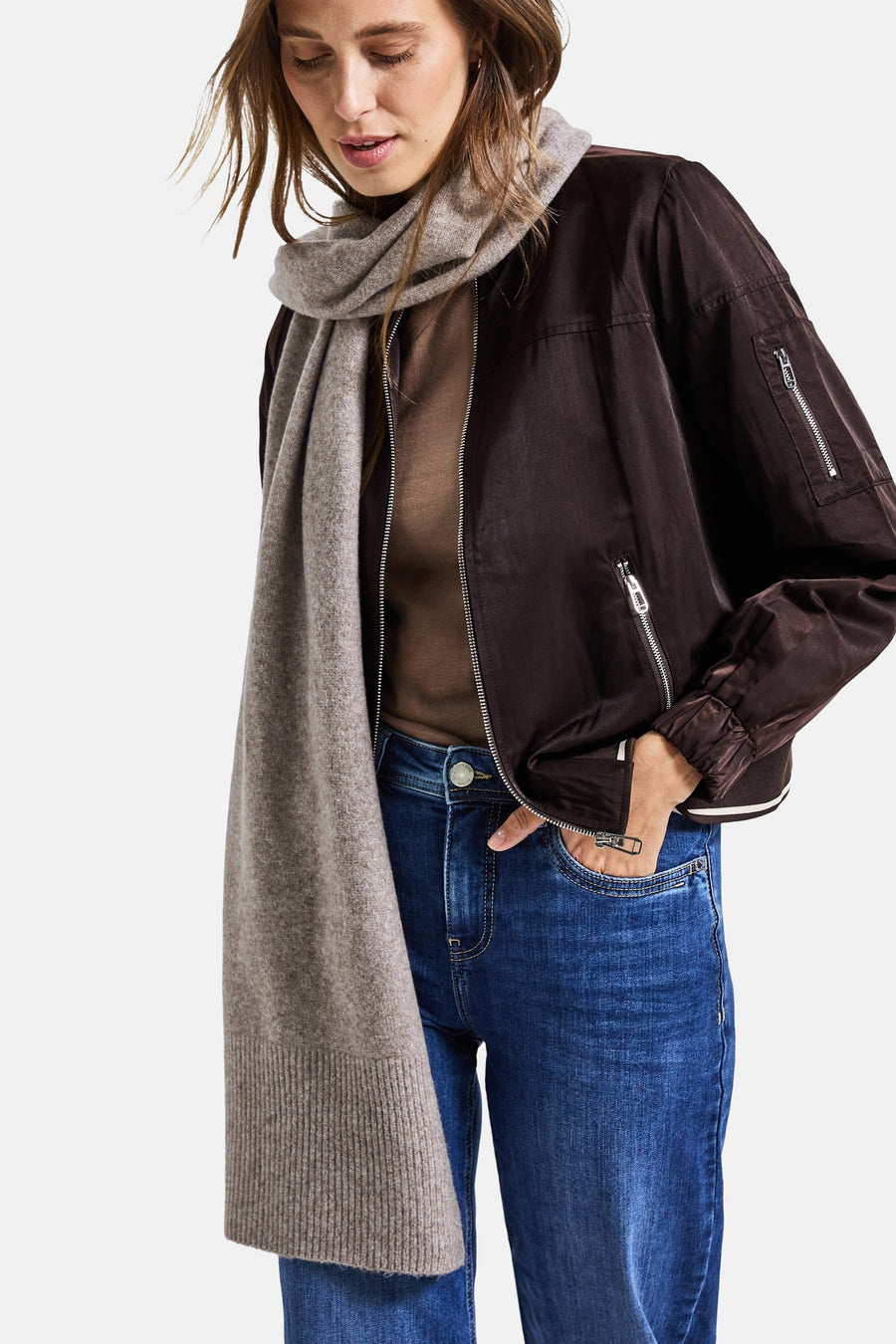 Lichtbruine sjaal van STREET ONE, gedragen om de nek met een bruin jack en een blauwe jeans.