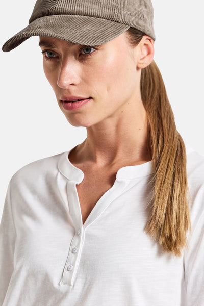 Beige pet van Street One, van ribfluweel, gedragen met een wit T-shirt met knopen.