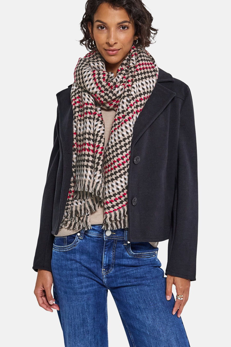 Multikleurige sjaal van Street One, met pied-de-poule patroon en rode accenten, gedragen met een kort jasje en een blauwe jeans.