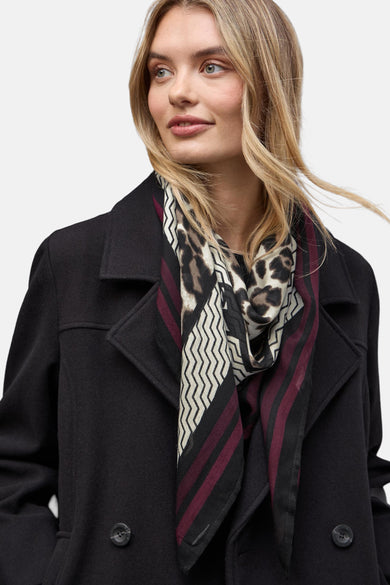 Foulard multicolore de Street One avec un motif léopard, rayures bordeaux et chevrons sur une femme portant un manteau noir.