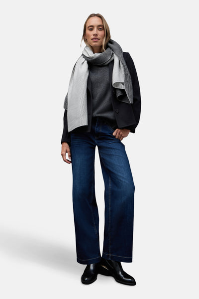 Écharpe gris chiné de Street One, avec un motif à rayures, portée avec un pull gris et un manteau noir.
