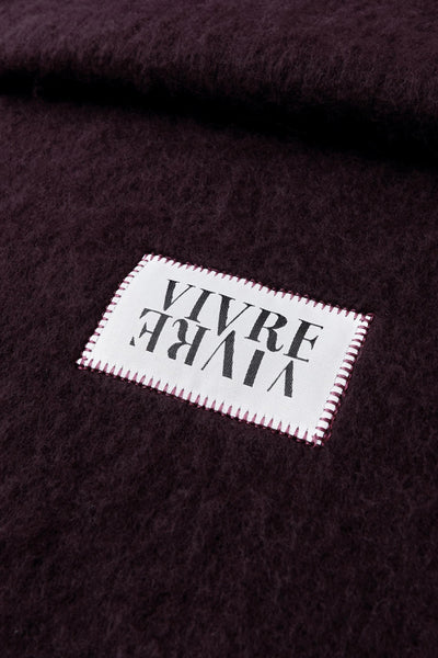 Écharpe bordeaux du STREET ONE avec une étiquette blanche cousue, présentant une texture duveteuse.
